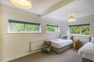 a bedroom with two beds and two windows at The Laurels - Wifi, Parking, 4 Bedrooms, Gatwick in Crawley