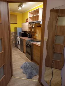 a kitchen with yellow walls and wooden cabinets at Apartament-Mieszkanie Gniezno-na doby in Gniezno