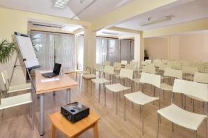 パンポロボにあるPamporovo hotel Snezhanka A640の白い椅子とデスク上のノートパソコンが備わる教室です。 +32枚の写真