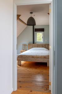 a bedroom with a large bed and a window at 't Jongehof in Zaffelare
