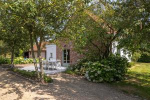 a brick house with a table and chairs in a yard at 't Jongehof in Zaffelare