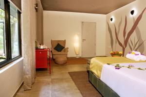 a bedroom with a bed and a chair in a room at Ela Luxury Stay in Vagamon