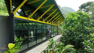 a building with a yellow and black facade with trees at Ela Luxury Stay in Vagamon