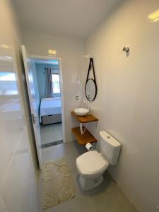 Un baño con inodoro, lavabo y cama. en Casa Solar, en Florianópolis