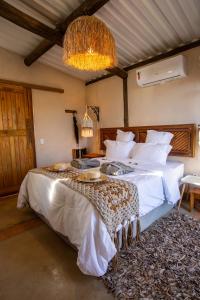 una camera da letto con un letto e un lampadario di Chalé Girassol - Vila Monte Cunha a Cunha