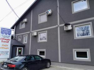 a black car parked in front of a building at Olimpic Apartmani BG in Batajnica