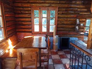 a dining room in a log cabin with a table and windows at Glamping Luxury Estancia CerroBlanco in Tanti