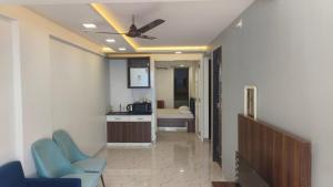 a living room with a ceiling fan and blue chairs at Seadeck Homestay in Harnai