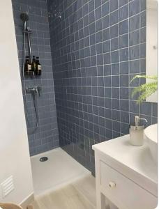 a blue tiled bathroom with a shower and a sink at Panoramic Faro Apartment in Faro +16 photos