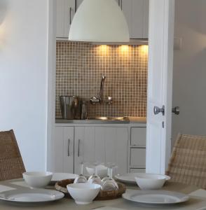 a kitchen with a table with white bowls on it at Panoramic Faro Apartment in Faro