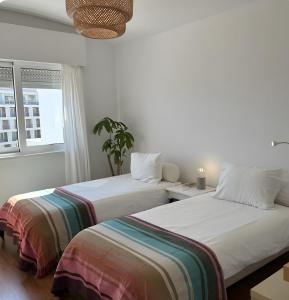two beds sitting next to each other in a bedroom at Panoramic Faro Apartment in Faro