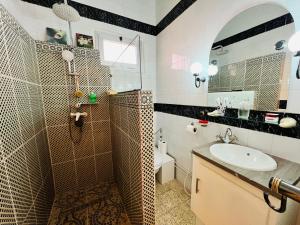 een badkamer met wastafel, douche en toilet bij Dar Othmen in Tozeur +25 foto's