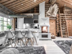 a kitchen with a fireplace in a log cabin at Villa RukanKelo in Ruka