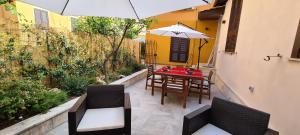 a patio with a table and chairs and an umbrella at Trastevere incantevole con patio esterno privato in Rome