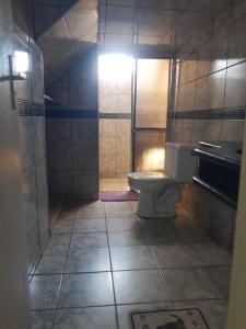 a small bathroom with a toilet and a sink at Pousada Roosevelt- suíte 1 in Uberlândia