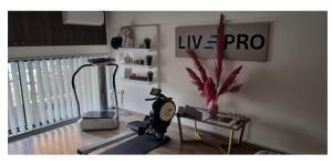 a living room with a treadmill and a table with a plant at LivePro in Larnaca