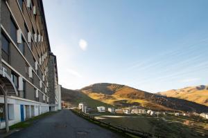 une rue vide à côté d'un bâtiment avec des montagnes en arrière-plan dans l'établissement L'Evasion des Sommets - Studio pieds des pistes, à Saint-Lary-Soulan