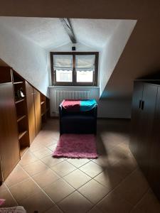 Habitación en el ático con silla y ventana en Appartamento Perla, en Aosta