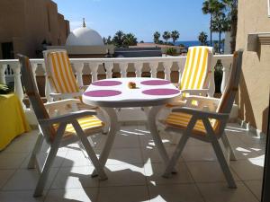 Una mesa y dos sillas en un balcón. en La Statue vue mer, en Csta Adje