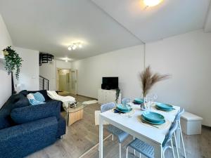 a living room with a white table and a blue couch at FREE PARKING - Stargate Budapest in Budapest