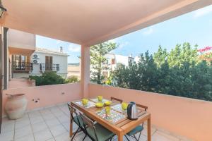 Un patio con una mesa y sillas en un balcón. en Residenza le Giare, en La Maddalena