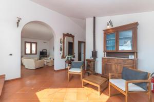 Una sala de estar con un sofá, una mesa y sillas. en Residenza le Giare, en La Maddalena