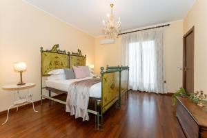 a bedroom with a bed and a chandelier at Aghi di Pino Holiday in Linera