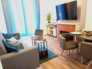a living room with a couch and a tv at Plein centre- 90m Cathédrale - 2ch - 4 couchages - 6 personnes in Amiens