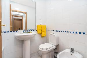 a white bathroom with a toilet and a sink at Sea Breeze in Portimão +14 photos