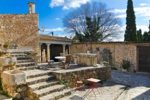 a stone house with stairs and a table and chairs at Casa Histórica con Piscina Sauna y Jacuzzi in Lloseta
