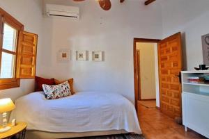 Un dormitorio con una cama con una almohada encima. en La Perla Andaluza, en Alcaucín