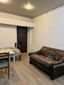 a room with a couch and a table and a room with a bed at Hostel EURO in Baku
