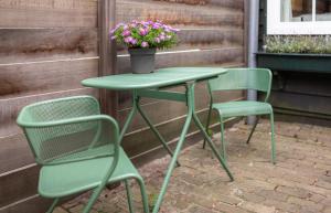 a green table with two chairs and a pot of flowers at The Little Nest - 2 guests - Zwolle in Zwolle