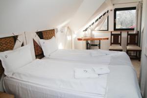 a bedroom with two white beds and a table at Conacul Lilium in Bran +50 photos