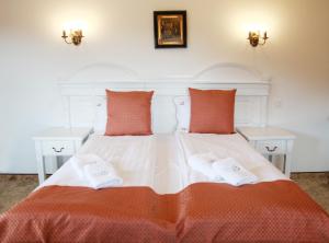 a white bed with two pillows and two tables at Conacul Lilium in Bran