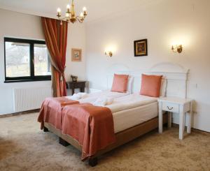 a bedroom with a large white bed with orange pillows at Conacul Lilium in Bran