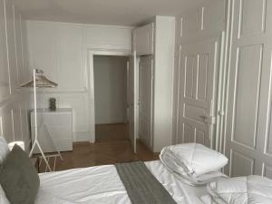 a white bedroom with a bed and a closet at The R Apartment Hurbig - Old Town in Schaffhausen