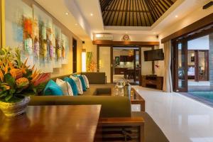 a living room with a couch and a table at Villa Green Mango 2 Seminyak Bali in Seminyak
