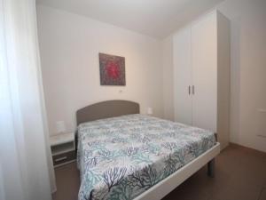 a bedroom with a bed and a painting on the wall at Renovated flat located in Rosolina near the sea in Rosolina Mare