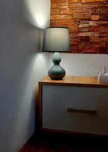 een lamp op een dressoir bij Lovely Central Apartment in Braşov +25 foto's