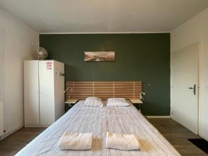 a large bed in a room with a green wall at Libourne centre in Libourne