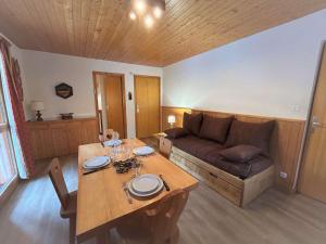 a living room with a table and a couch at Appartement en montagne, 4 pers, proche des pistes et commerces, animaux acceptés, balcon, casier à skis - FR-1-180-73 in Méribel
