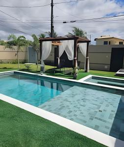 una piscina con gazebo accanto a una casa di Casa Lunna a Camaçari
