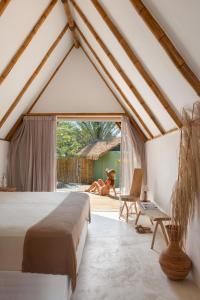 a bedroom with a bed and a dog laying on the floor at Cabanas Blue in Mata de Sao Joao