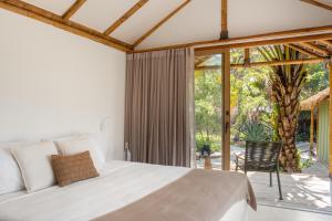 a bedroom with a bed and a large window at Cabanas Blue in Mata de Sao Joao