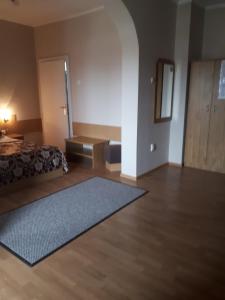 a bedroom with a bed and a rug on the floor at Hotel Perla in Satu Mare