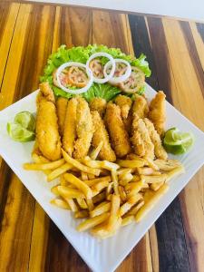 a plate of food with french fries and a sandwich at Pousada in Porto De Galinhas