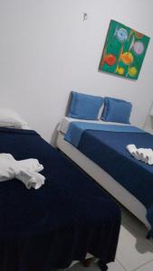 a bedroom with two beds and a painting on the wall at Pousada in Porto De Galinhas