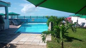 a swimming pool with a view of the ocean at Pousada in Porto De Galinhas