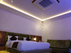 a bedroom with a bed and a couch at The Rules Club in Vrindāvan